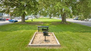 A park with a bench and a tree.